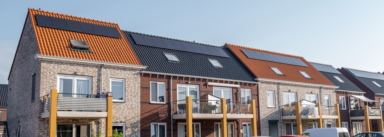 Nieuw gebouwde huizen met zonnepanelen op het dak met op de achtergrond een mooie blauwe lucht