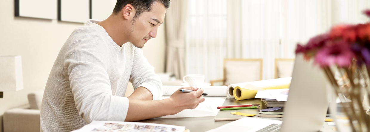 Aziatische man die thuis aan het werk is al designer